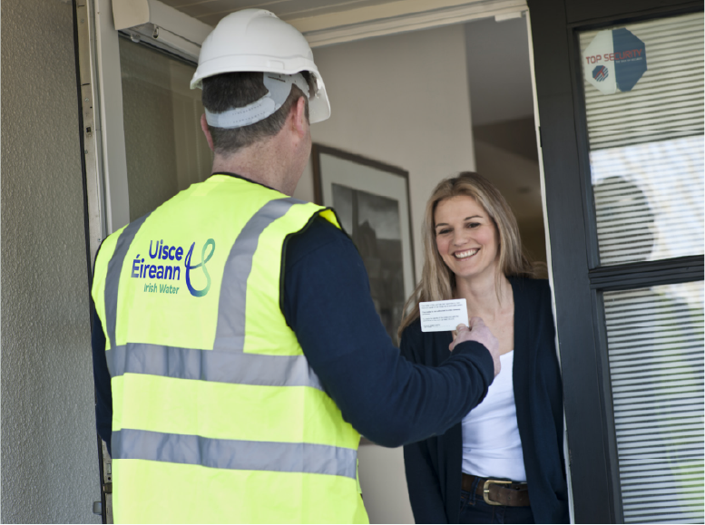 Uisce Eireann representative presenting identification while being greeted by female occupant ofthe house.