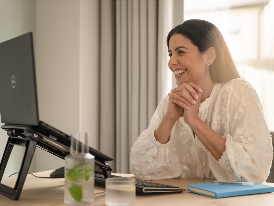 Female in work-from-home environment engaging in a video call on laptop.