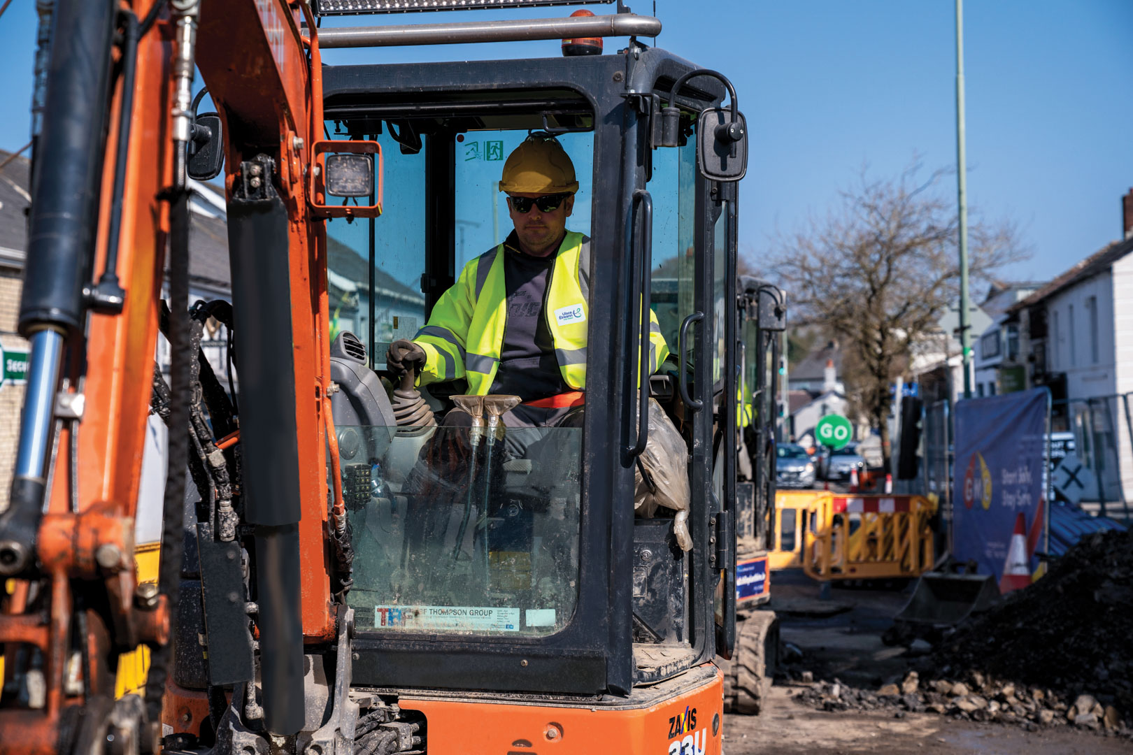 An Uisce Éireann worker in a digger on a roadworks site
