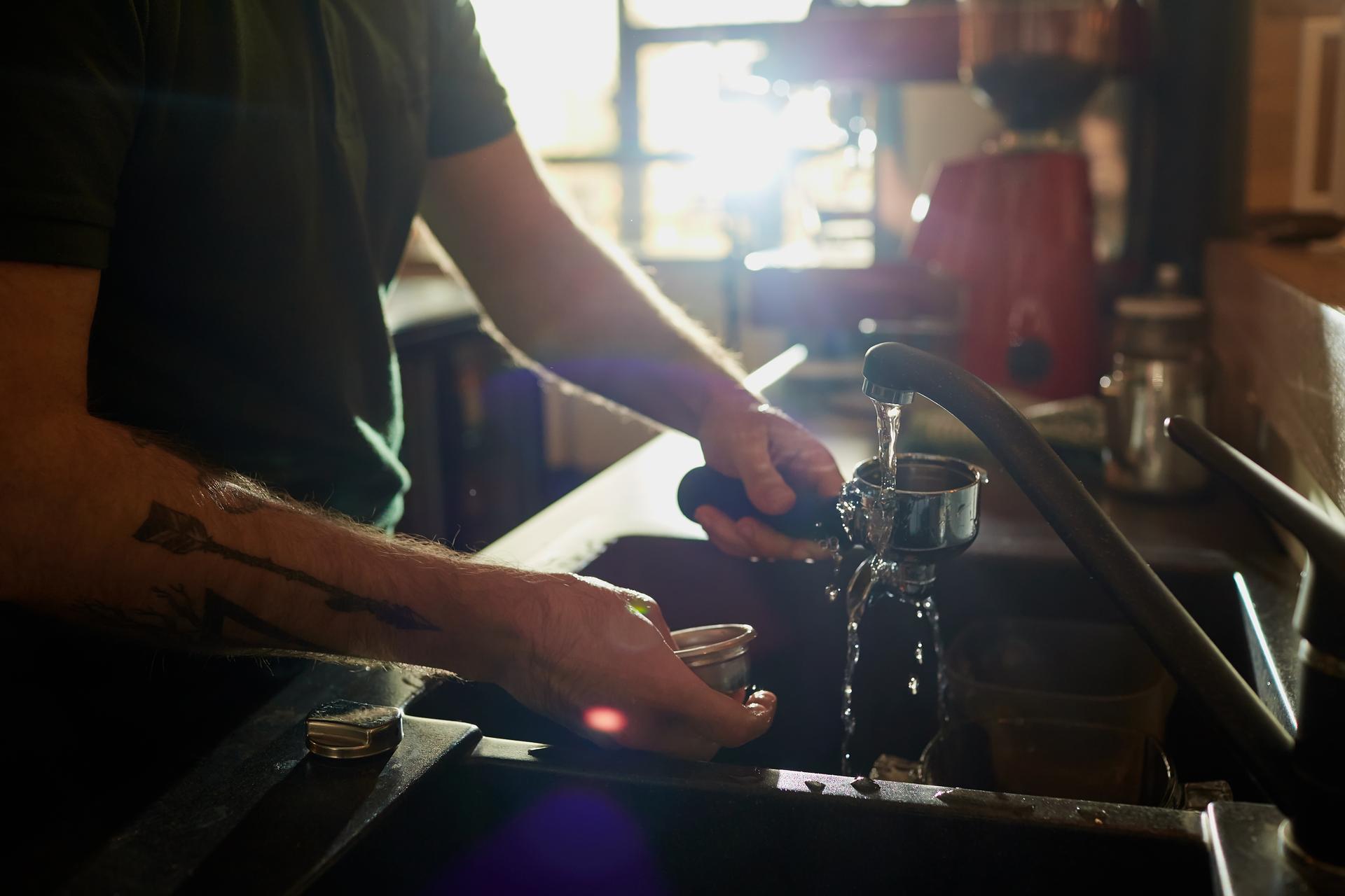 Barista cleaning coffee equipment