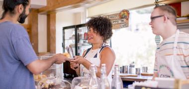 A waitress serving food to a man at a cafe