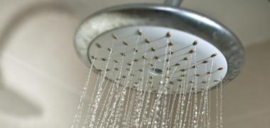 A shower head with water coming through the openings
