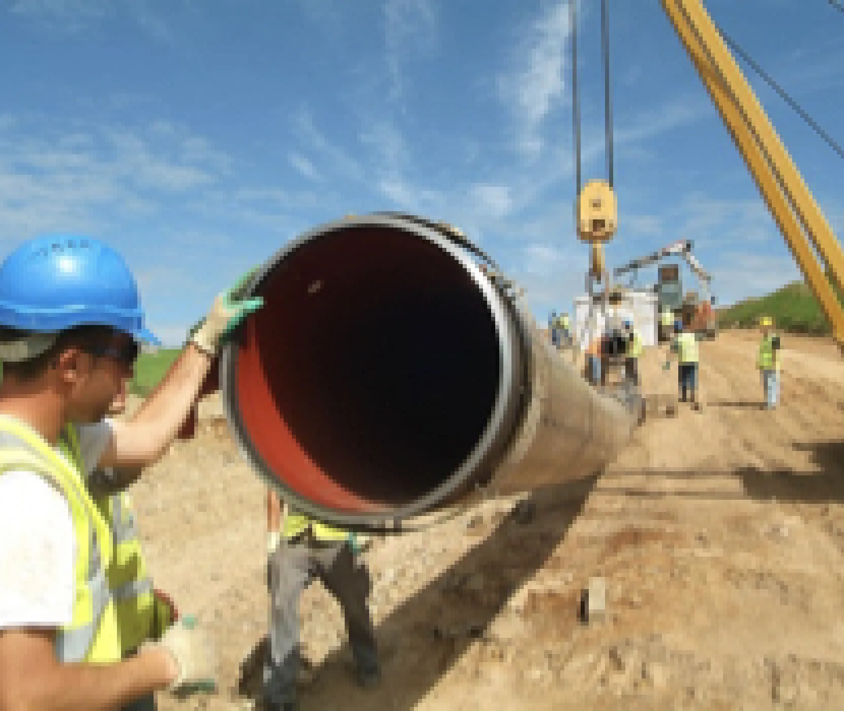 An Uisce Éireann worker with his hand on a large pipe on a construction site