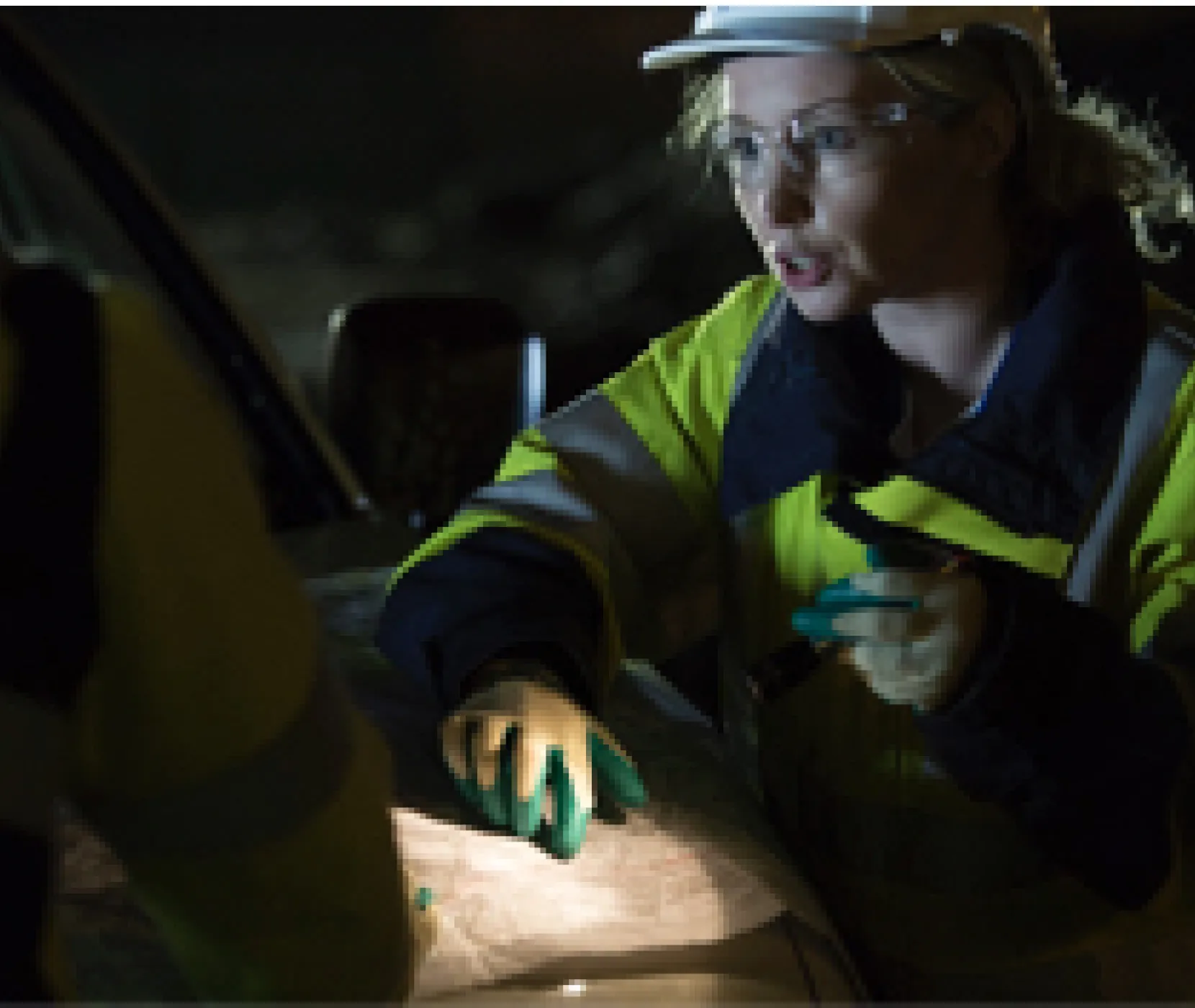 An engineer pointing at a map at night
