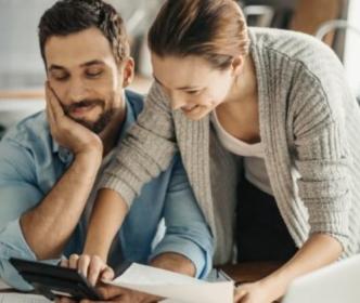 A man and woman calculating figures using a calculator